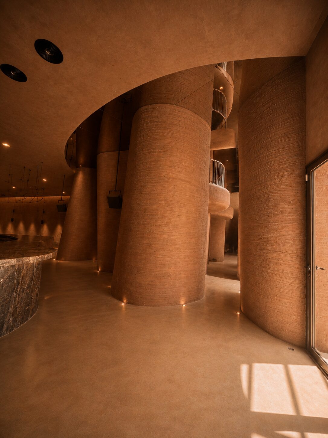 Bro Club bar beside terracotta-textured cylindrical columns and curved balconies