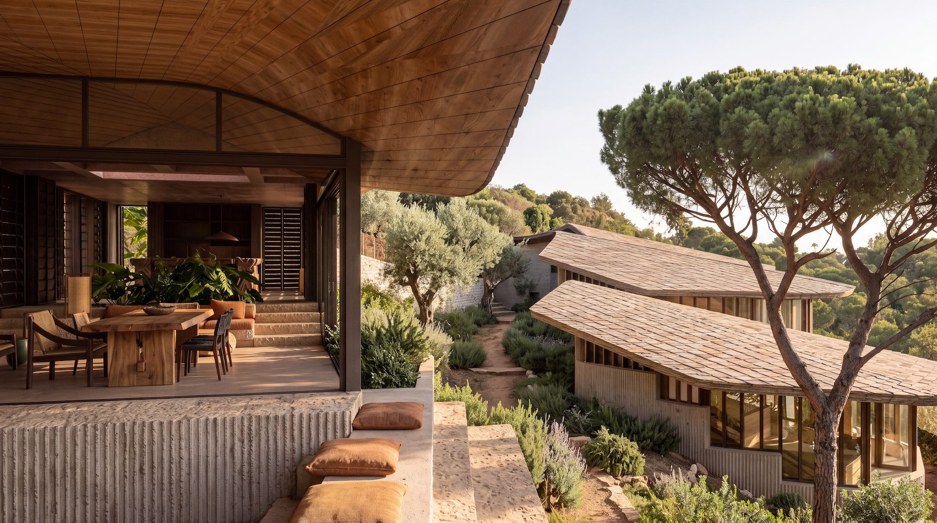 Render de la terraza cubierta de Villa Petra: techo curvo de madera, mesa de comedor de madera maciza, muro de hormigón abujardado con cojines y pabellones con cubierta de teja junto a un pino piñonero